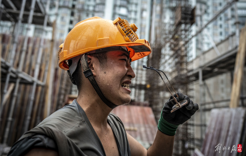 Everywhere is "hot", and under the scorching sun, the steel scaffolding looks like a large steamer surrounded by migrant workers in hot weather