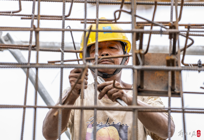 Everywhere is "hot", and under the scorching sun, the steel scaffolding looks like a large steamer surrounded by migrant workers in hot weather