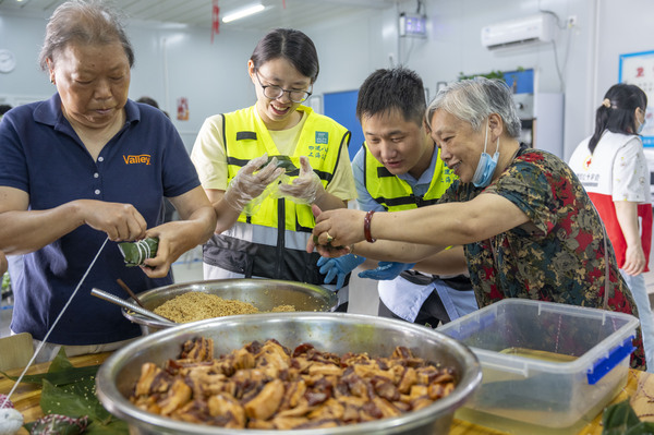 这个工地请来社区居民一起体验端午民俗,挂菖蒲、包粽子、做香囊端午节包粽子